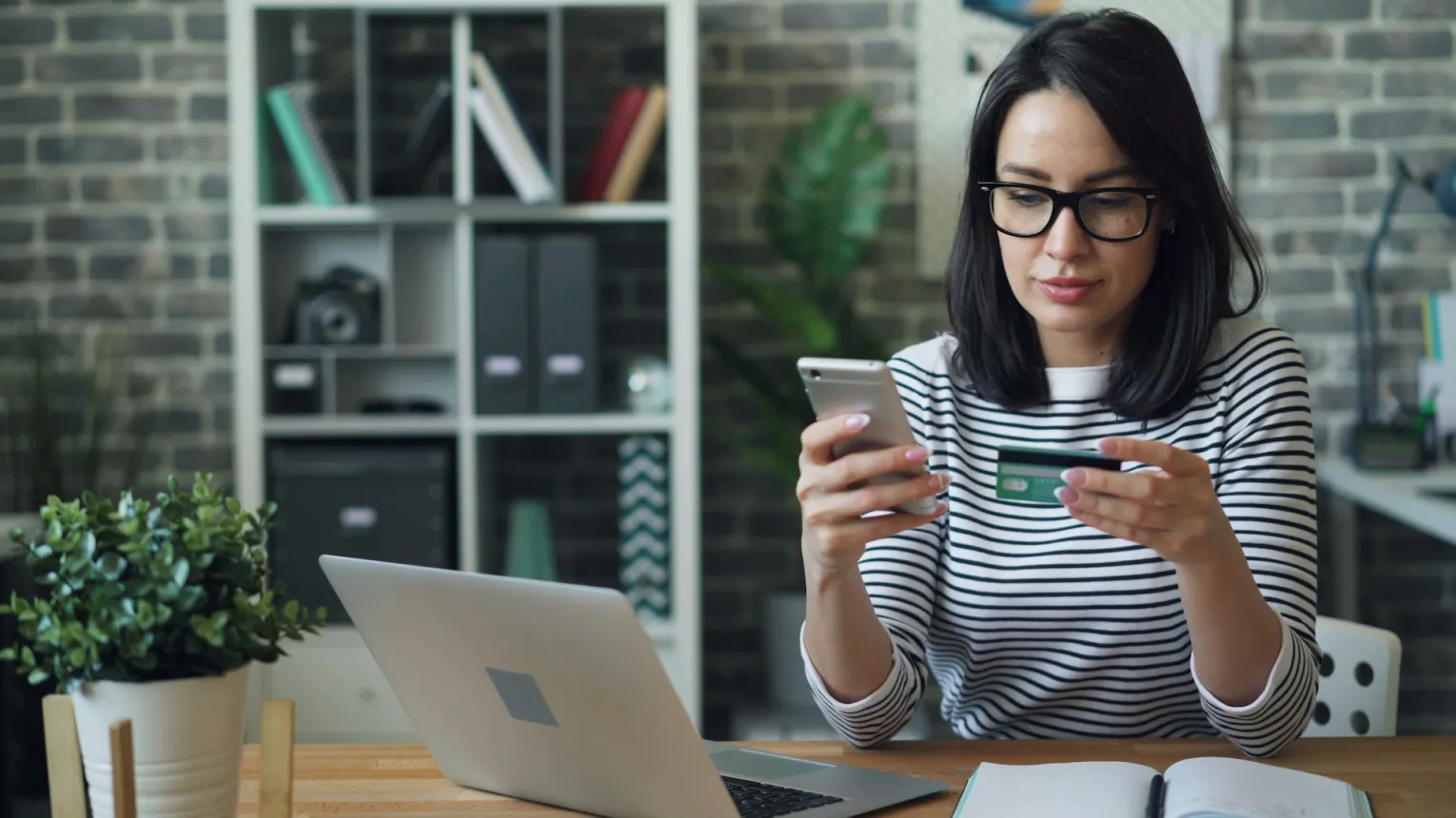 UK consumer holding a credit card as household bills and living costs rise